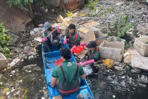 Các tình nguyện viện chèo thuyền dọn rác trên con kênh thuộc phường Bình Quới (TPHCM). Ảnh: Phúc Uyên.