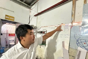 Ông Nguyễn Anh Sơn chỉ tay vào những vết nứt tường do công trình xây dựng kế bên gây ra. (Ảnh: Hà An)