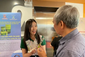 Phạm Ngọc Hà, học viên cao học tại Trường Đại học Đà Lạt giới thiệu khách tham quan sản phẩm thức ăn dinh dưỡng từ bèo tấm. Ảnh: Hà An.