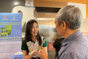 Phạm Ngọc Hà, học viên cao học tại Trường Đại học Đà Lạt giới thiệu khách tham quan sản phẩm thức ăn dinh dưỡng từ bèo tấm. Ảnh: Hà An.