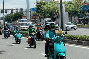 Xe điện và xe xăng chạy trên đường Phạm Văn Đồng, TPHCM. Ảnh: Hà An.