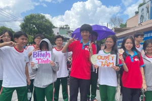 Nhóm tình nguyện viên tại điểm thi trường THCS Thái Văn Lung, TP Thủ Đức tự làm bảng cổ động, thiệp chúc thí sinh. Ảnh: Hà An.