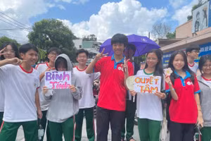 Nhóm tình nguyện viên tại điểm thi trường THCS Thái Văn Lung, TP Thủ Đức tự làm bảng cổ động, thiệp chúc thí sinh. Ảnh: Hà An.