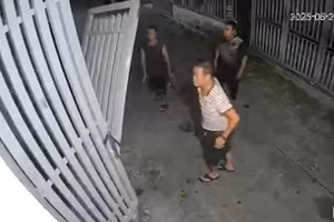 Bùi Hữu Khánh (áo sọc trắng) kéo sập cửa nhà hàng xóm vì bị phản ánh hát karaoke. (Ảnh cắt từ clip)