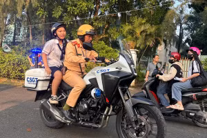 Đại úy Tạ Minh Thắng chở nữ sinh để quên giấy tờ tại điểm thi ở Hóc Môn, TPHCM. Ảnh: Phúc Uyên.