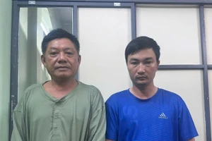 Mai Đình Bá (phải) và Nguyễn Hùng tại cơ quan điều tra. (Ảnh: Công an TPHCM)