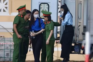 Hoa hậu Thùy Tiên (áo xanh dương) được lực lượng chức năng đưa xuống xe chuyên dụng. Ảnh: Phúc Uyên