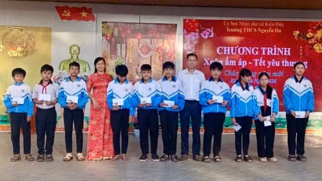 Bà Trần Thị Hồng, Phó Hiệu trưởng Trường THCS Nguyễn Du trao quà tết cho học sinh.