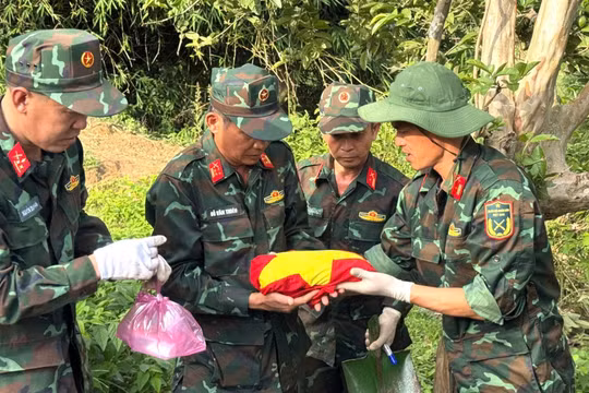 Hài cốt liệt sĩ Y Chông Triêk được các cán bộ, chiến sĩ nâng niu trong màu cờ đỏ sao vàng.