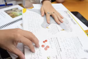 Học viên sử dụng sách chữ nổi. Ảnh: BTC. 