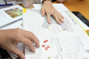 Học viên sử dụng sách chữ nổi. Ảnh: BTC. 