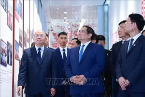 Thủ tướng Phạm Minh Chính nghe giới thiệu về quá trình phát triển của Sàn giao dịch chứng khoán Thượng Hải. Ảnh: Dương Giang/TTXVN