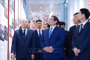 Thủ tướng Phạm Minh Chính nghe giới thiệu về quá trình phát triển của Sàn giao dịch chứng khoán Thượng Hải. Ảnh: Dương Giang/TTXVN