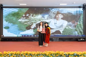 Nguyễn Thị Cẩm Giang (sinh viên năm 2, ngành Logistics và quản lý chuỗi cung ứng) thay người anh quá cố nhận tấm bằng tốt nghiệp. Ảnh: NTTU. 