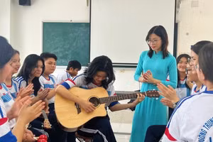 Cô Nguyễn Thị Thanh Thảo cùng học sinh học đàn Ghi - ta. Ảnh: NVCC. 