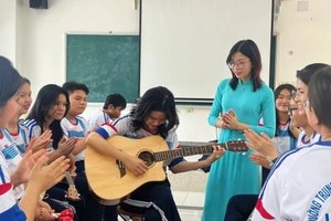 Cô Nguyễn Thị Thanh Thảo cùng học sinh học đàn Ghi - ta. Ảnh: NVCC.