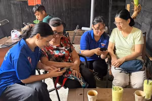 Tình nguyện viên hỗ trợ người dân cài đặt các ứng dụng chuyển đổi số trong đời sống hằng ngày. Ảnh: Mặt trận phường Bình Thạnh. 