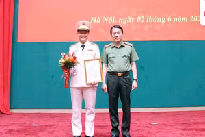 Đại tướng Lương Tam Quang, Bộ trưởng Bộ Công an trao Quyết định thăng cấp bậc hàm lên Thiếu tướng đối với Đại tá Nguyễn Ngọc Quyền (bên trái). Ảnh: Minh Đức.