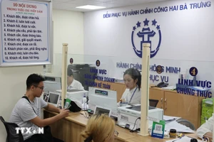 Người dân được cán bộ, công chức hỗ trợ giải quyết hồ sơ tại Điểm phục vụ Hành chính công phường Hai Bà Trưng (Hà Nội). (Ảnh: Vũ Quang/TTXVN).