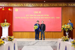 PGS.TS Vũ Văn Nhiêm - Chủ tịch Hội đồng trường (phải) tặng hoa cho TS Lê Trường Sơn - Hiệu trưởng Trường Đại học Luật TPHCM. Ảnh: HCMULAW. 