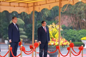 Thủ tướng Phạm Minh Chính và Thủ tướng Nhật Bản Ishiba Shigeru trên bục danh dự, nghe quân nhạc cử Quốc thiều hai nước. (Ảnh: Dương Giang/TTXVN)