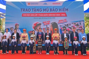 Các đại biểu trao tặng mũ bảo hiểm cho các em học sinh lớp Một trường Tiểu học Lê Quý Đôn. Ảnh: Honda.