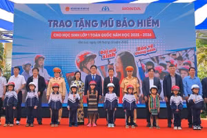 Các đại biểu trao tặng mũ bảo hiểm cho các em học sinh lớp Một trường Tiểu học Lê Quý Đôn. Ảnh: Honda.