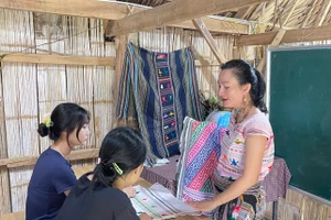Nghệ nhân Châu Mạ hướng dẫn sinh viên tìm hiểu chi tiết thổ cẩm dân tộc Châu Mạ. Ảnh: NVCC.