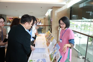 Đại biểu tham quan sách tại sự kiện. Ảnh: RtR. 