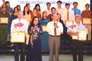 Thầy Cao Xuân Lương (trái) nhận giải thưởng Cuộc thi sáng tác học tập và làm theo Bác Hồ. Ảnh: TG.