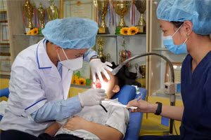 Bác sĩ Trung tâm y tế Quận 5 thực hiện khám răng cho học sinh dưới sự giám sát của các bác sĩ của Bệnh viện Răng Hàm Mặt Trung ương TPHCM. (Ảnh: SYT)
