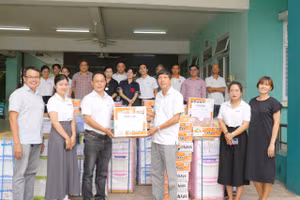 Nhà báo Nguyễn Anh Tú trao quà cho ông Đinh Hữu Tuyến – Giám đốc Trung tâm Bảo trợ trẻ em Tam Bình.