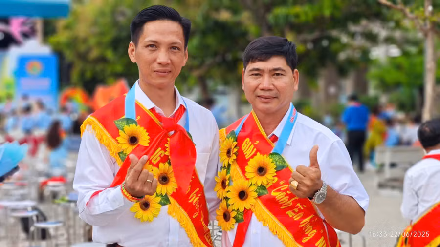 Thầy Trịnh Hoàng Thám (bên trái) chụp ảnh cùng đồng nghiệp khi nhận giải thưởng Cánh én hồng 2025.