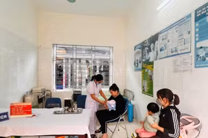 Người dân tiêm phòng Sởi cho con tại Trung tâm Y tế huyện Kiến Thuỵ.
