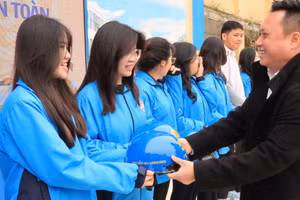 Đại diện nhà tài trợ trao tặng mũ bảo hiểm cho học sinh.