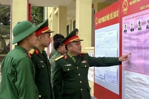 Cán bộ, chiến sĩ Tiểu đoàn phòng thủ đảo Bạch Long Vĩ đang xem tiểu sử tóm tắt những người ứng cử đại biểu Quốc hội khóa XVI. (Ảnh: CTV)