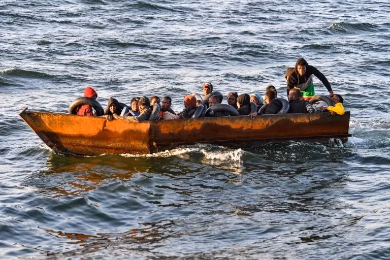 Người tị nạn từ vùng Hạ Sahara ngồi trên một chiếc thuyền tạm bợ bị lực lượng chức năng Tunisia chặn lại cách bờ biển thành phố Sfax khoảng 50 hải lý trên Địa Trung Hải.