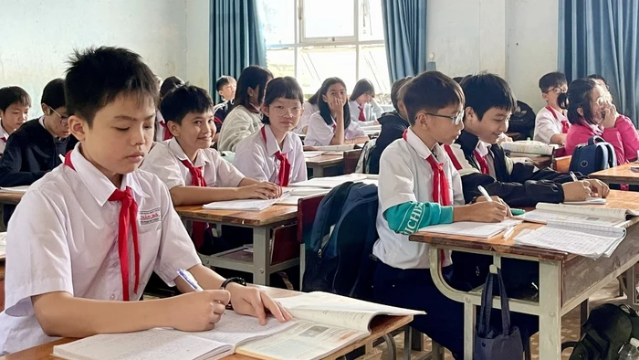 Một số học sinh bị hư hỏng sách giáo khoa trong đợt mưa lũ, phải dùng chung sách với bạn để chờ được hỗ trợ. Ảnh: Dung Nguyễn