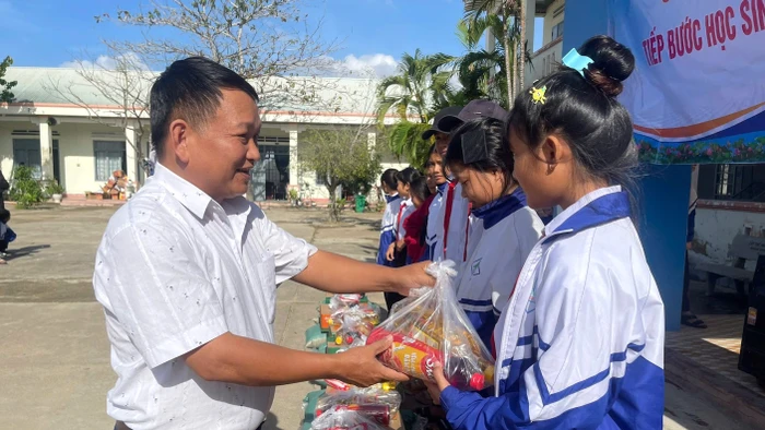 Thầy Vũ Văn Tùng - Trường Tiểu học và THCS Đinh Núp (Gia Lai) mang những phần quà đến học sinh vùng khó.