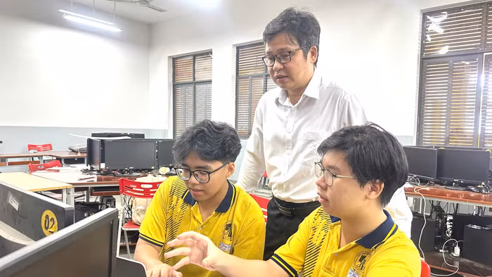 Tấn Đức (bên phải) và Nhật Bảo bàn luận về dự án cùng thầy hướng dẫn Đỗ Quốc Anh Triết. Ảnh: MA