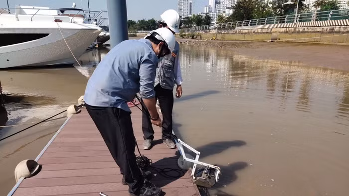 Thu mẫu bùn tại nhà máy giấy để phân tích trong đề tài nghiên cứu. Ảnh: NVCC
