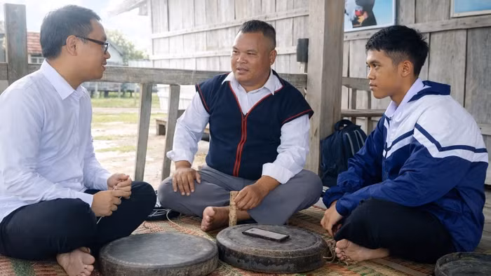 Nghệ nhân Đinh Hdot hướng dẫn Bùi Thành Luân và Y Sơn Việt cách chỉnh chiêng truyền thống.