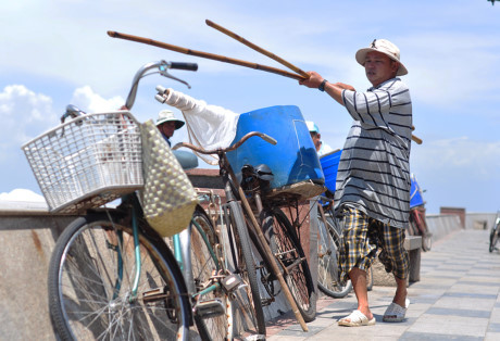 Cha truyền con nối nghề ném đá lùa cá vào bờ ở biển Vũng Tàu - Ảnh 1 Cha truyen con noi nghe nem da lua ca vao bo o bien Vung Tau - Anh 1