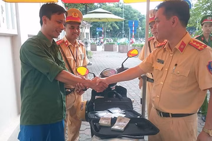 Anh Hoàng Văn Đức được lãnh đạo đội CSGT trao trả lại 70 triệu đồng bị mất. Ảnh: CTV