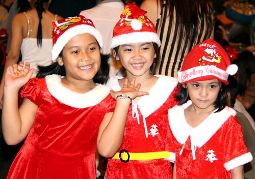 Dù trời mưa lất phất nhiều em nhỏ ở TP.HCM vẫn được bố mẹ chở ra đường để vui Noel. Ảnh: Hữu Công. noel8-3898-1387904006.jpg