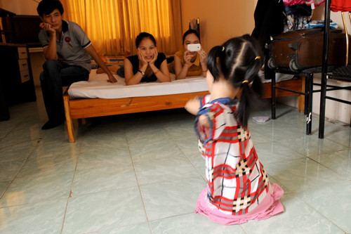 Bố mẹ đang chăm chú xem con gái nhảy Gangnam Style. Đây là phút đoàn tụ hiếm hoi của gia đình bé Chi trong thời gian điều trị chỉnh hình tại Hà Nội. Chị Thủy không coi con gái là một gánh nặng trách nhiệm. Dù con gái khuyết tật, đối với chị Thủy, bé vẫn là niềm tự hào.