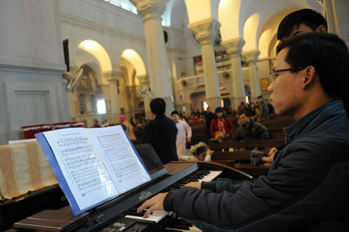 Nhà thờ Cửa Bắc vắng vẻ hơn so với Nhà thờ Lớn. Một nhạc công đang chuẩn bị các bản nhạc cho buổi lễ. Ảnh: Quý Đoàn. 6-2-2961-1387905471.jpg