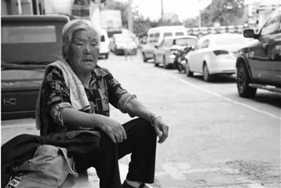 Bà nội 8 tiếng mỗi ngày chờ cháu ở cổng trường ảnh 1 Bà Chen ngồi vỉa hè được nhiều người đề nghị hỗ trợ tiền ăn, chỗ ngủ... nhưng bà luôn từ chối. Ảnh: China News.