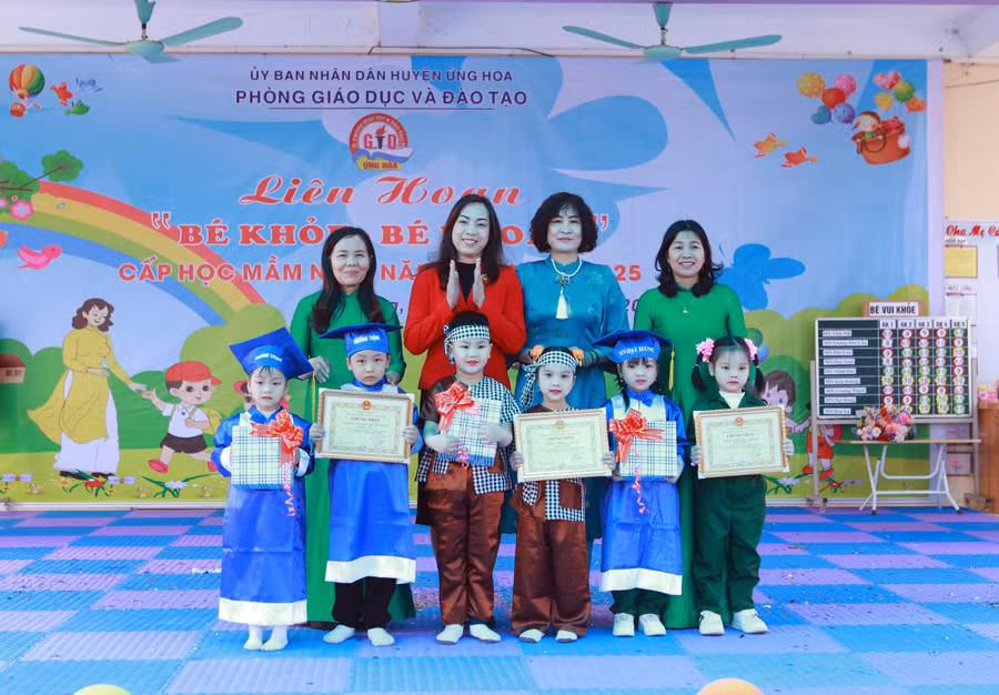 Bà Đinh Thị Bích Thủy - Trưởng Phòng Giáo dục Mầm non thuộc Sở GD&ĐT Hà Nội trao thưởng cho đại diện cô trò 3 nhà trường đạt giải Nhất của hội thi. 