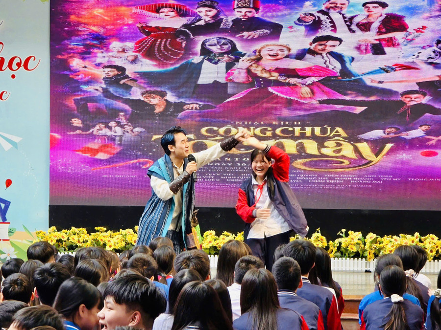 Học sinh tham gia giao lưu cùng nghệ sĩ biểu diễn nhạc kịch tại sân trường. 